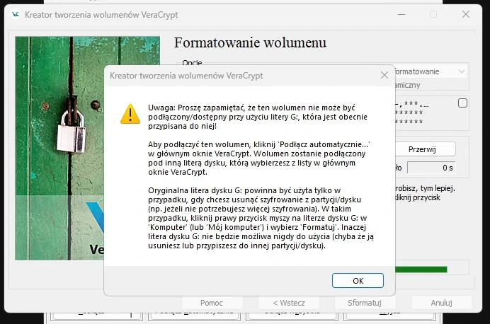 Komunikat VeraCrypt informujący, że wolumen nie będzie dostępny pod dotychczasową literą dysku G: i że należy go podłączać przez „Podłącz automatycznie” pod inną literą.
